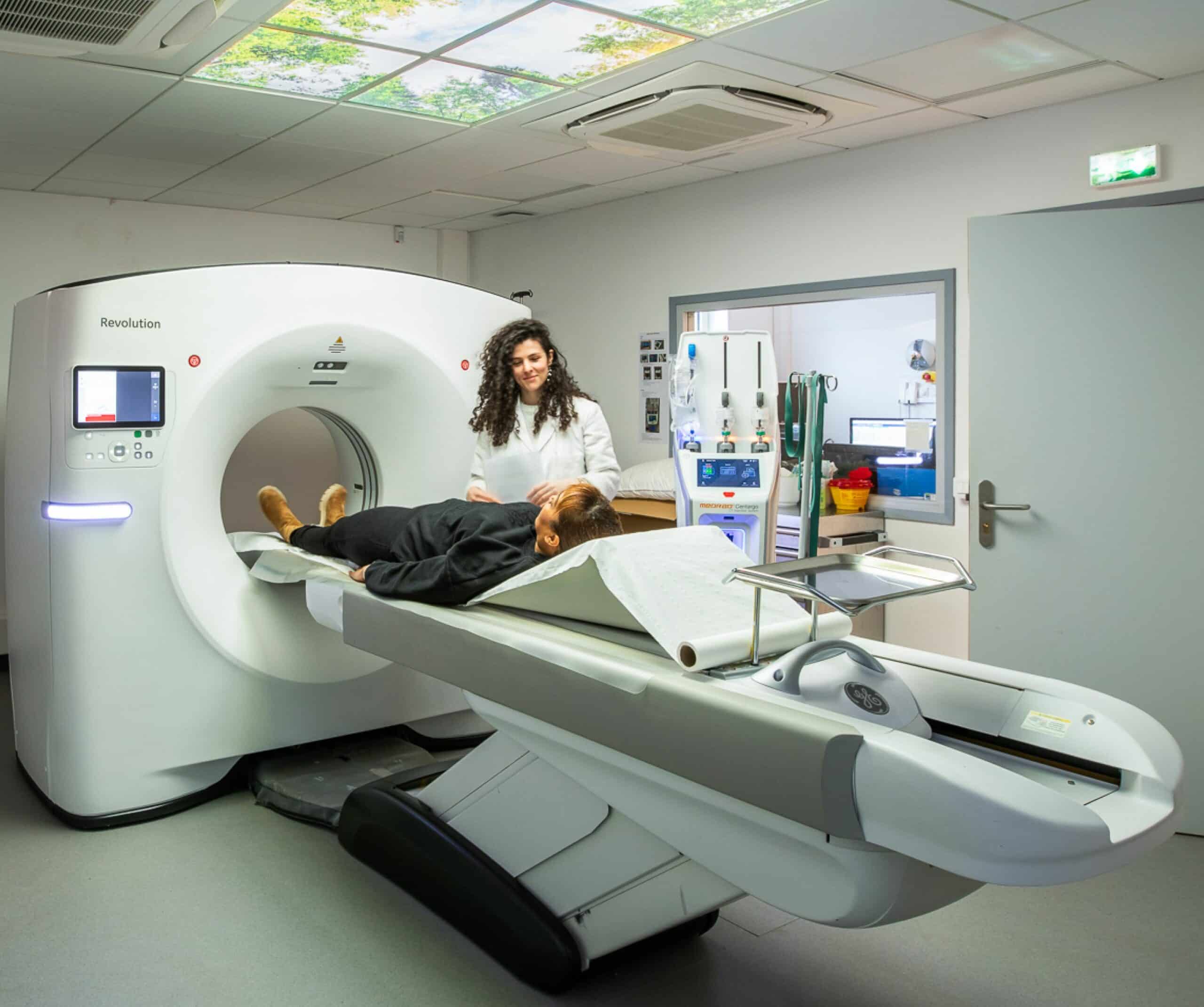patiente allongee sur un scanner assistee par une radiologue plateau technique | radiologie interventionnelle IMEF